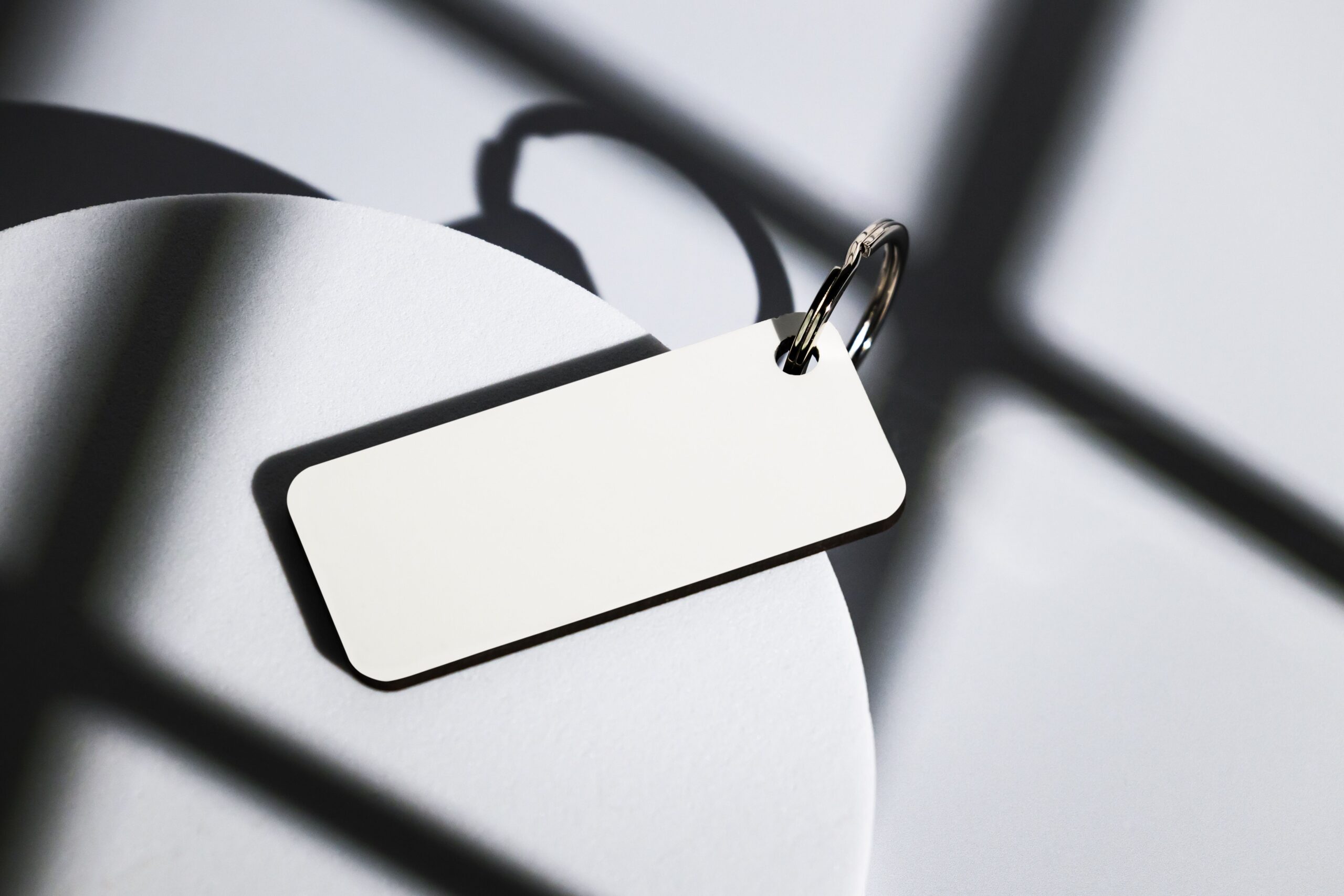 Elegant keychain on abstract shadows cast by natural light, close-up shot.
